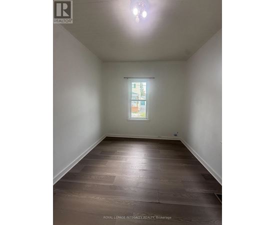 A room with wooden flooring and a window.
