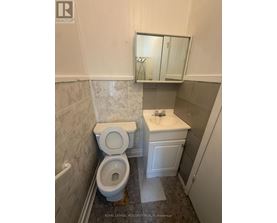 A white toilet and sink in a small bathroom.