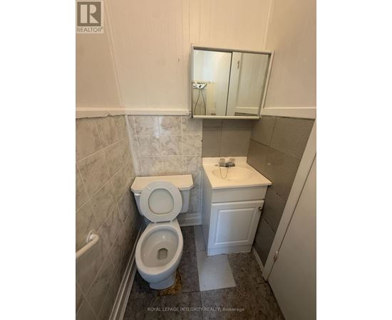 A white toilet and sink in a small bathroom.