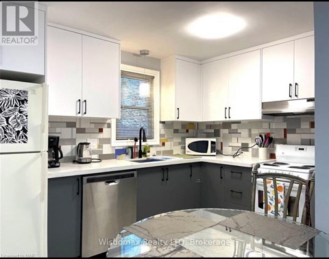 A kitchen with white cabinets and a marble table.