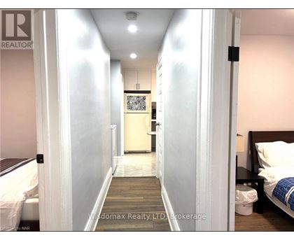 A hallway with a bedroom at the end.