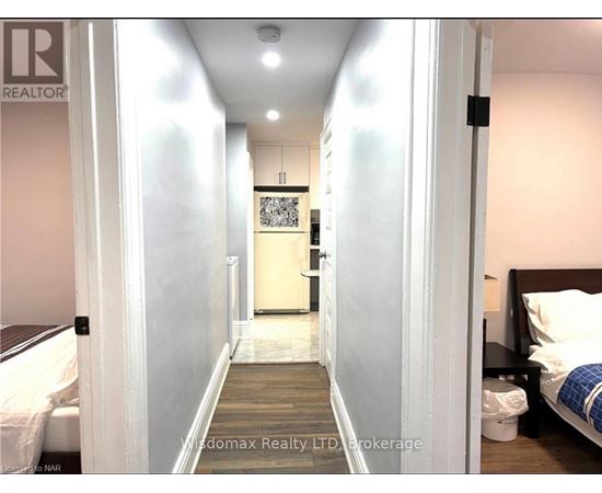 A hallway with a bedroom at the end.