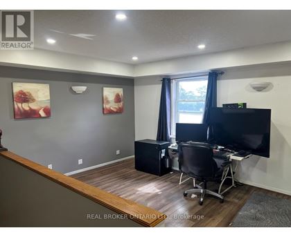 A room with a desk, chair, and television.