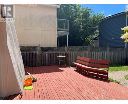 A red wooden deck with a bench and a table.