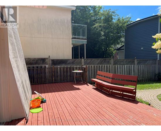 A red wooden deck with a bench and a table.
