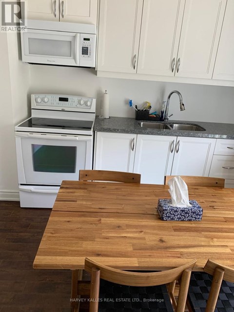 A kitchen with a wooden table and white cabinets.