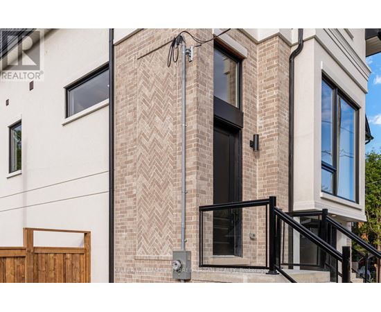 A modern house with a brick facade and a black door.