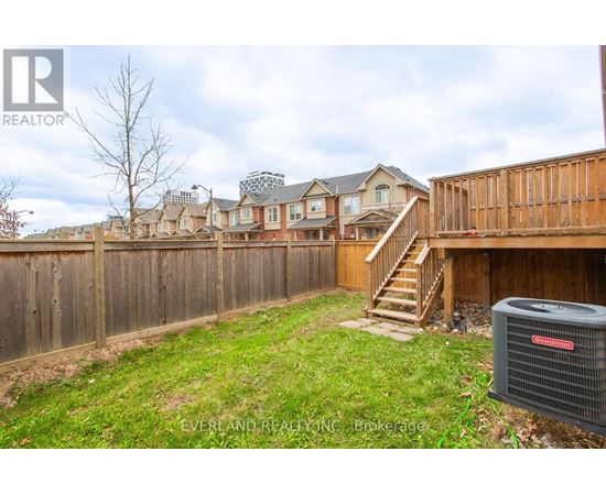 A backyard with a fence and a heat pump.