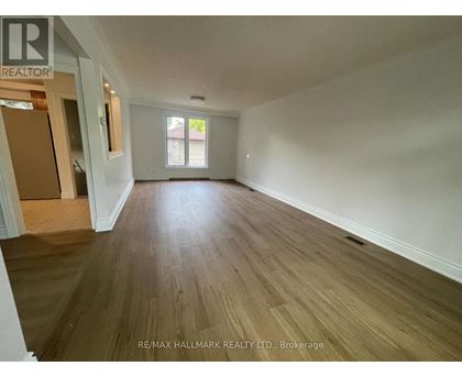 A room with wooden flooring and a window.