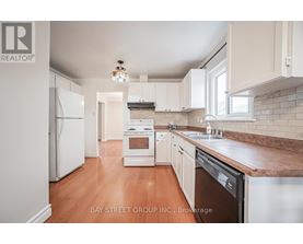 A kitchen with white appliances and wooden floors.