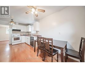 A kitchen with white cabinets and a wooden table with chairs.