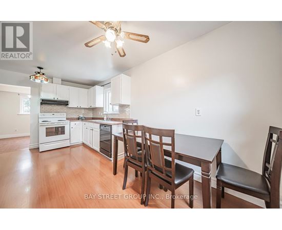 A kitchen with white cabinets and a wooden table with chairs.