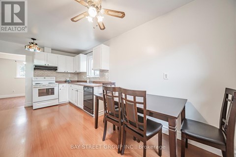 A kitchen with white cabinets and a wooden table with chairs.