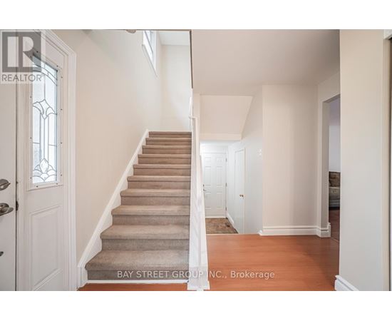 A staircase with a carpeted runner and white walls.