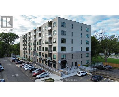 A large apartment building with a parking lot in front.
