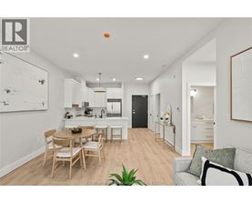 A well-lit, modern kitchen and dining area with a wooden table and chairs.