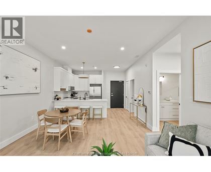 A well-lit, modern kitchen and dining area with a wooden table and chairs.