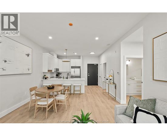 A well-lit, modern kitchen and dining area with a wooden table and chairs.