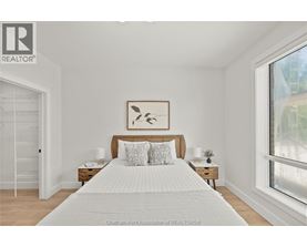 A bedroom with a large bed and a painting above it.