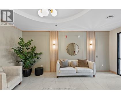 A living room with a white couch and a round mirror on the wall.