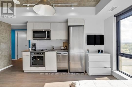 A modern kitchen with stainless steel appliances and white cabinetry.