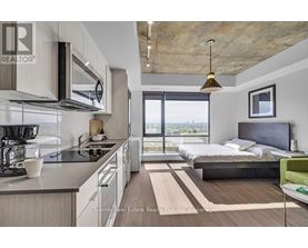 A modern kitchen with a large island and a bedroom with a large bed and a view.