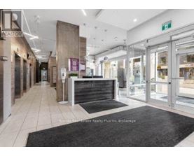 The image shows the interior of a realtor's office with a reception desk and glass doors.