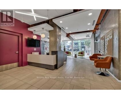 A reception area with a red door and a flat screen TV mounted on the wall.