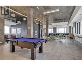 A pool table is in the middle of a room with chairs around it.