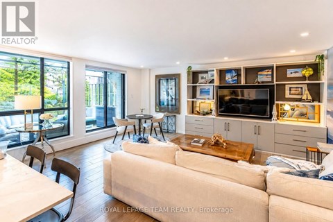 A living room with a white couch and a television on a cabinet.