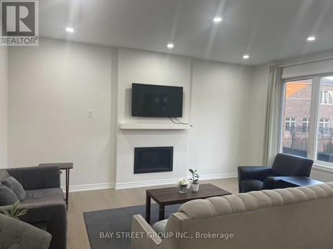 A living room with a fireplace and a flat screen TV mounted above it.