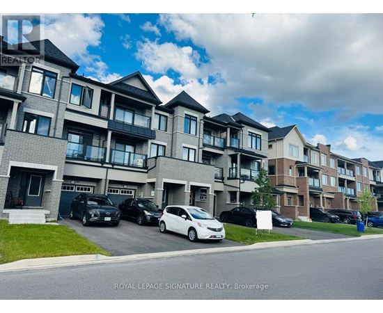 A white car is parked in front of a building with a sign that says "Royal LePage Signature Realty, Brokerage.".