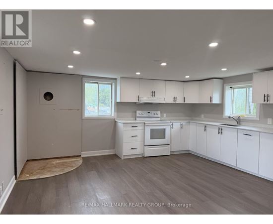 A kitchen with white cabinets and a wood floor.