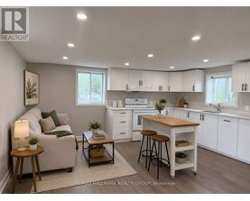 A well-lit, modern kitchen with white cabinets and a wooden island.