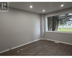 A room with a window showing trees outside.