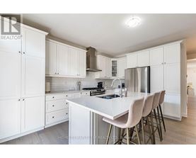 A kitchen with white cabinets and a white island.