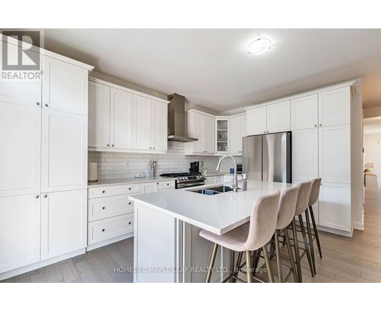 A kitchen with white cabinets and a white island.