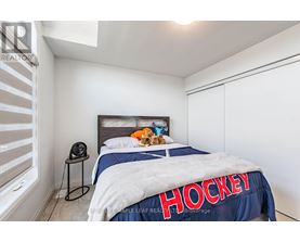 A bedroom with a bed covered in a blanket that says Hockey.