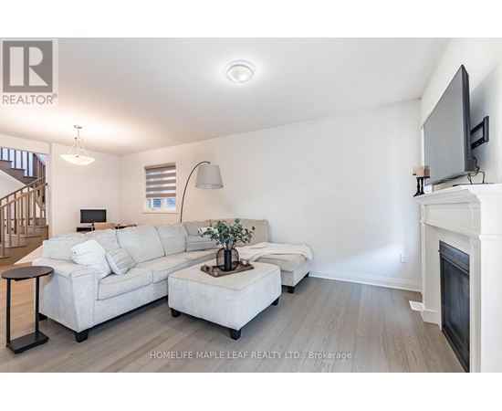 A living room with a white couch and a television on the wall.