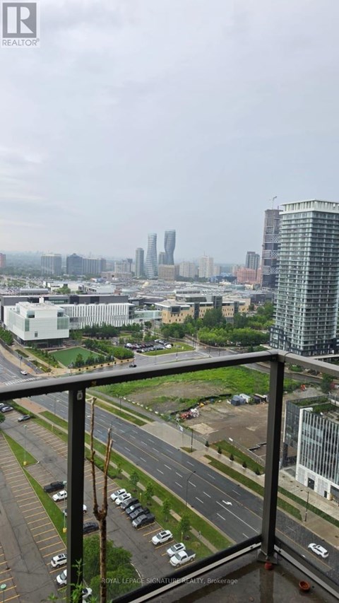 A cityscape with tall buildings and a cloudy sky.