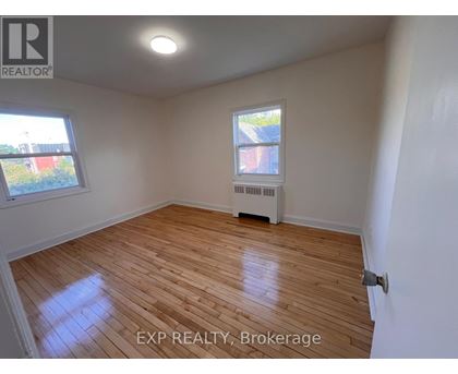 A room with wooden flooring and a window.