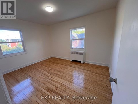 A room with wooden flooring and a window.