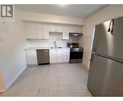 A kitchen with white cabinets and a stainless steel refrigerator.