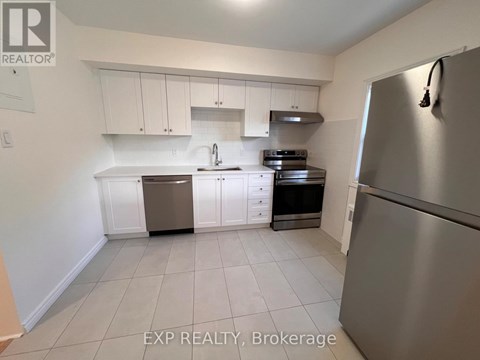 A kitchen with white cabinets and a stainless steel refrigerator.