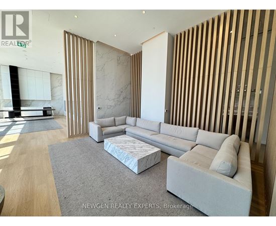 A modern living room with a grey sofa and a wooden panelled wall.