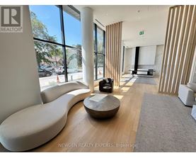 A modern waiting room with a curved white sofa and a wooden coffee table.