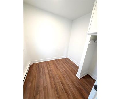 A room with wooden flooring and white walls.