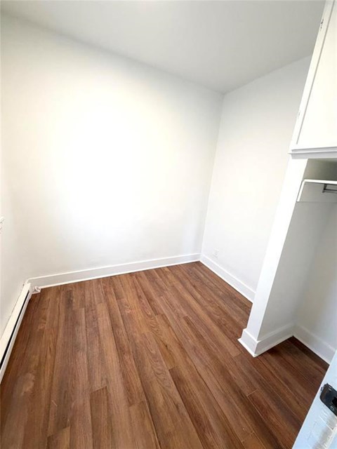 A room with wooden flooring and white walls.