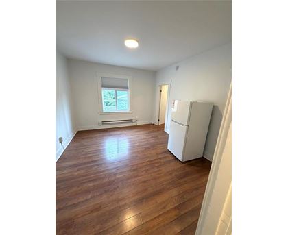A room with wooden flooring and a window.