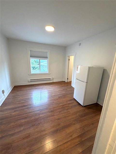 A room with wooden flooring and a window.